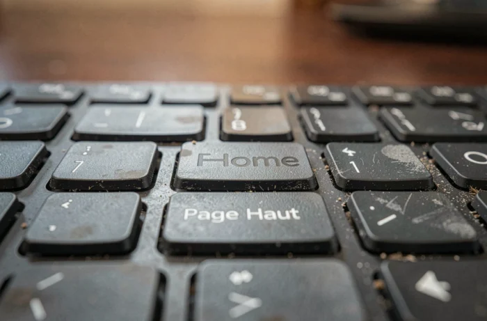 Gros plan sur la touche Home d'un clavier AZERTY avec les touches environnantes visibles